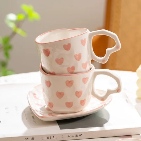 White heart-shaped cup and saucer with pink heart pattern