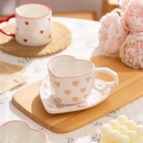 White heart-shaped cup and saucer with pink heart pattern - The Traveling Teapot
