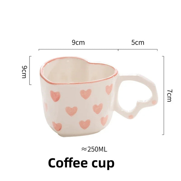 White heart-shaped cup and saucer with pink heart pattern