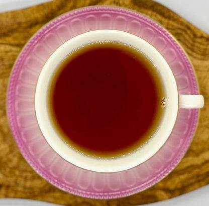 Lavender peach black tea brewed hot in a pink teacup